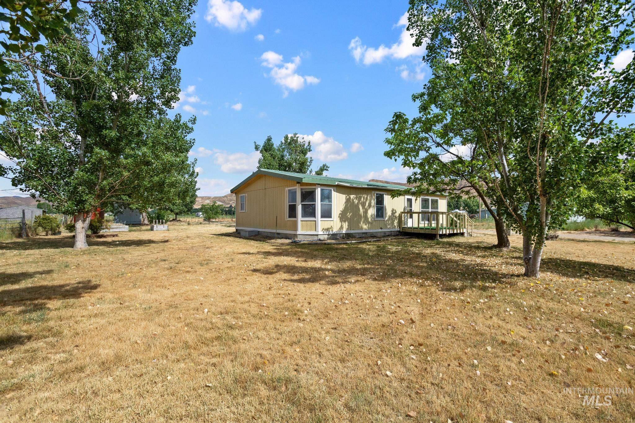 3680 South Mill Road Emmett, ID 83617 - Photo 7 of 38 Single-story dwelling with light yellow siding and a green roof