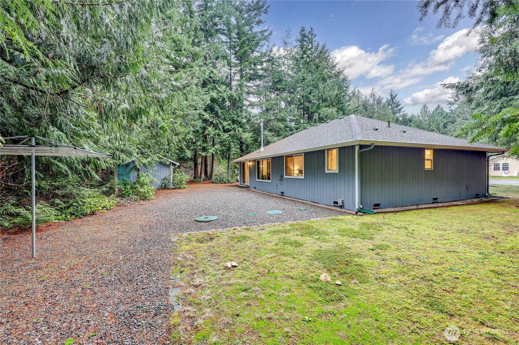 43 Rhody Court Chimacum, WA 98325 - Photo 8 of 37 a backyard of a house with large trees and table and chairs