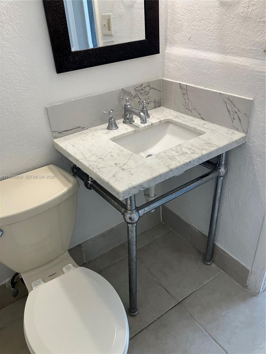 5730 Southwest 37th Street Davie, FL 33314 - Photo 14 of 20 a bathroom with a granite countertop toilet sink and mirror