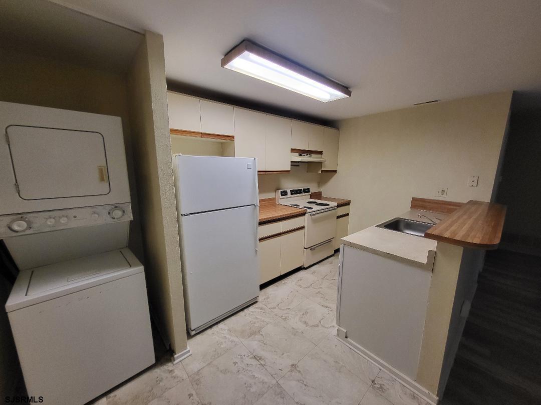 9 Malibu Way, Unit 9 Galloway Township, NJ 08205 - Photo 4 of 6 a kitchen with a refrigerator and a washer dryer