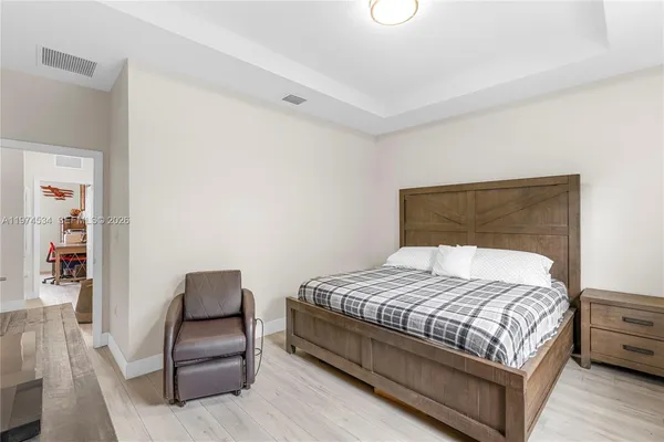 a large bed sitting in a bedroom next to a lamp with a table and chair