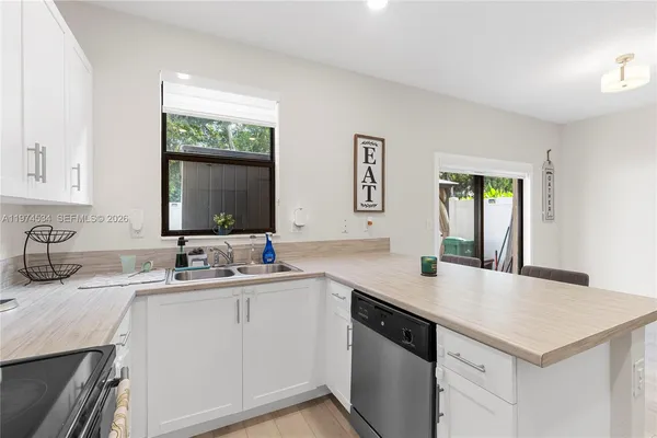 a view with a sink cabinets and a wooden floor