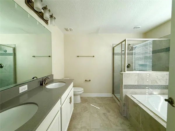 a bathroom with a granite countertop sink and a large mirror
