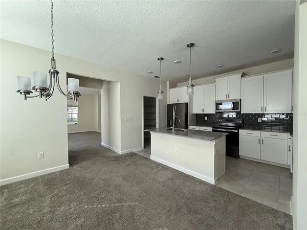 a kitchen with stainless steel appliances a refrigerator sink and white cabinets