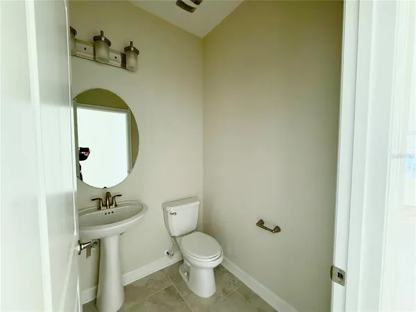 a bathroom with a sink toilet and a mirror