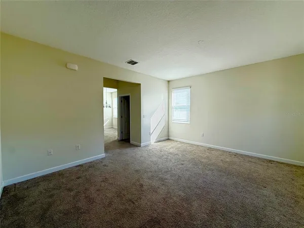 an empty room with closet and windows