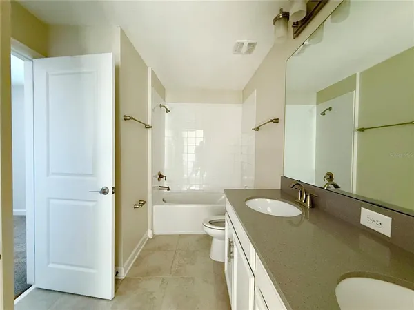 a bathroom with a sink a toilet a mirror and shower