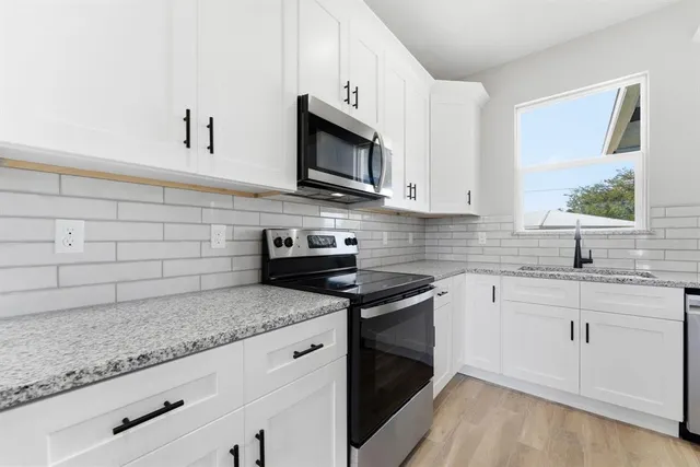 a kitchen with stainless steel appliances granite countertop a sink stove and microwave