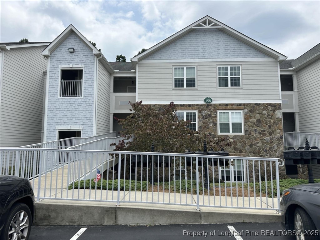 158 Gallery Drive, Unit 202 Spring Lake, NC 28390 - Photo 1 of 22 a view of a house with a small yard and wooden fence