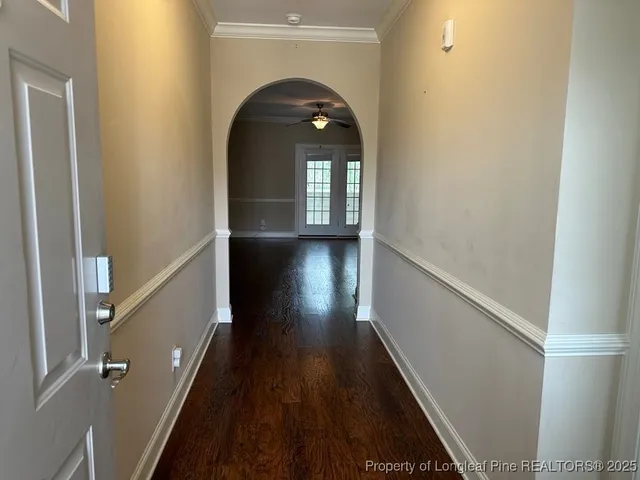 a view of a hallway of wooden floor with staircase