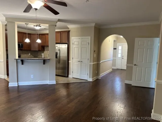 a view of a livingroom with wooden floor and a kitchen