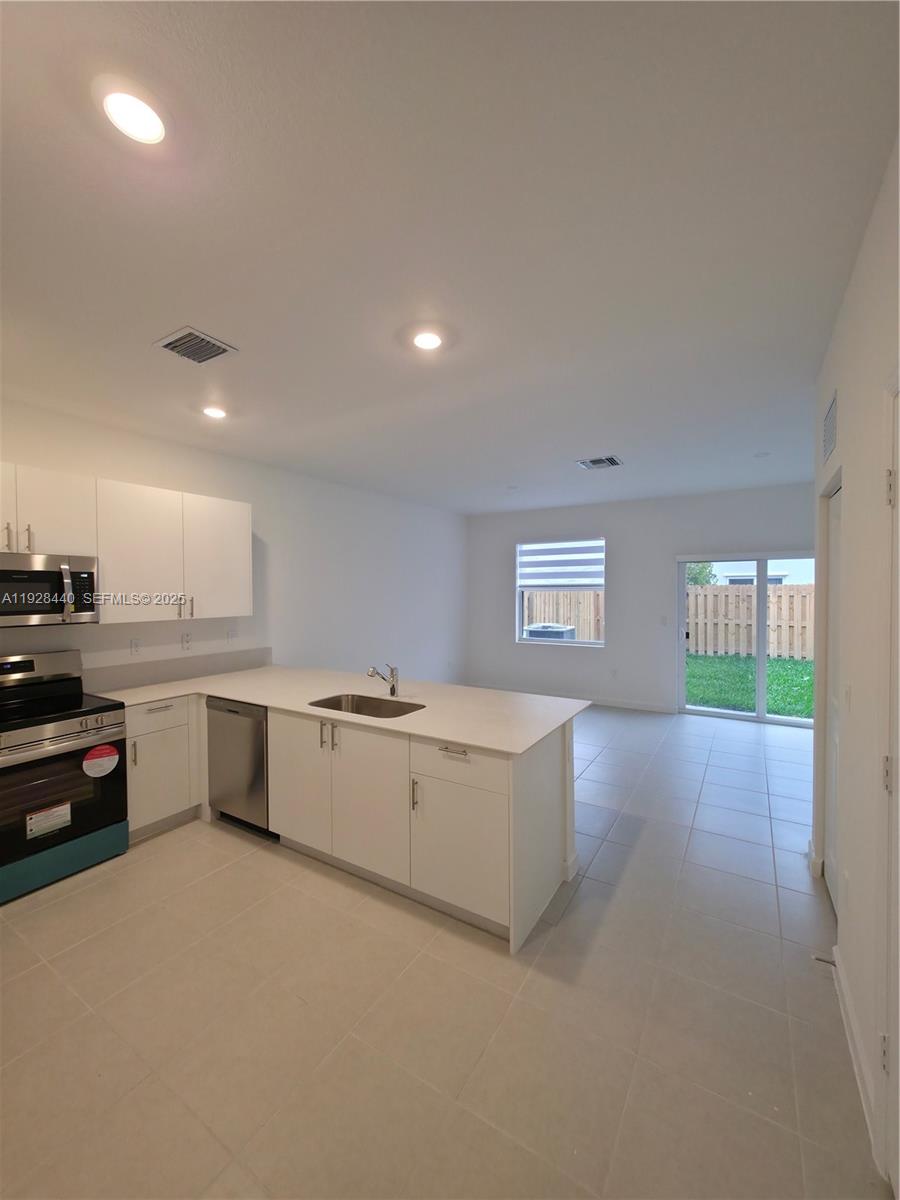 35687 Southwest 178th Court Homestead, FL 33034 - Photo 6 of 28 a kitchen with a refrigerator and a stove top oven