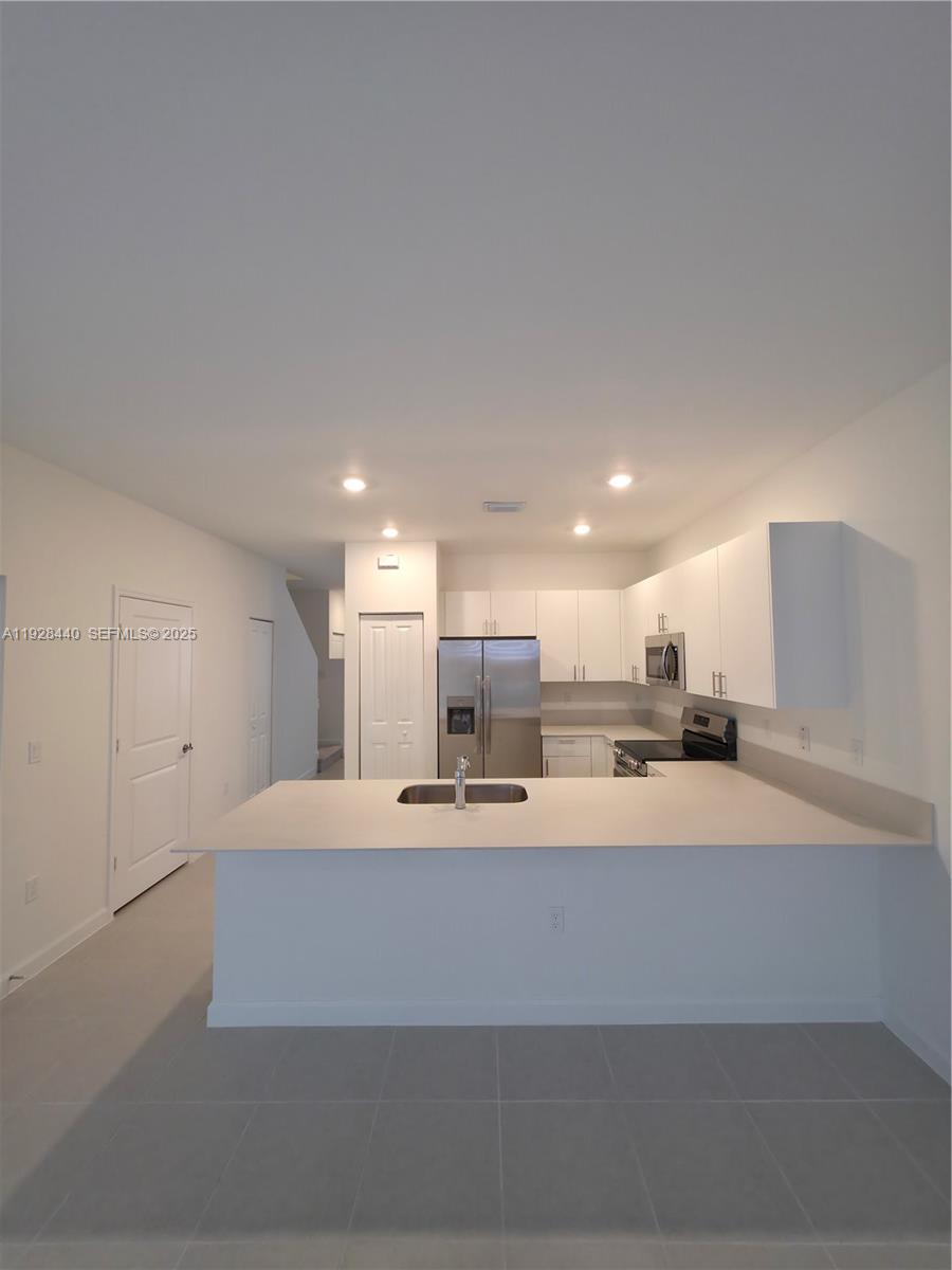 35687 Southwest 178th Court Homestead, FL 33034 - Photo 10 of 28 a large white kitchen with kitchen island a sink a stove and a refrigerator