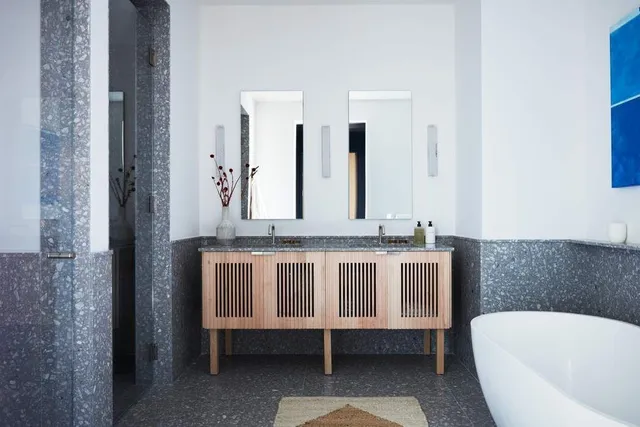 a bathroom with a tub a sink and a mirror