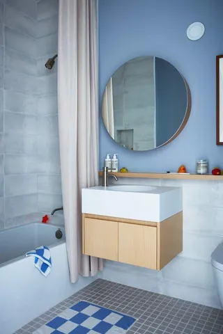 a bathroom with a tub sink and mirror