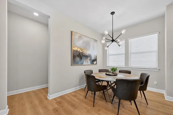 a dining room with furniture a chandelier and wooden floor