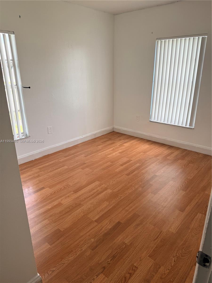 26468 Southwest 123rd Place Homestead, FL 33032 - Photo 20 of 33 an empty room with wooden floor and sliding door