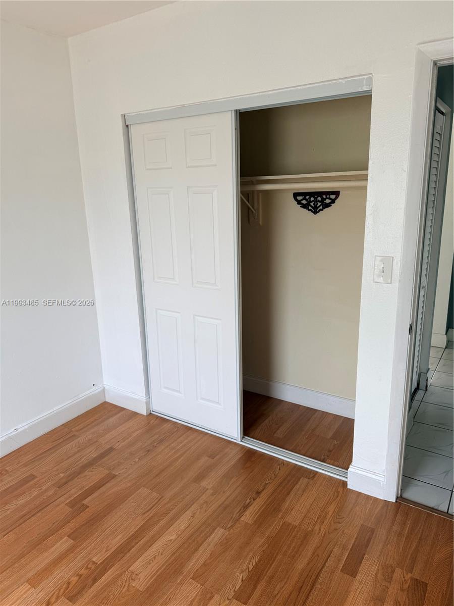 26468 Southwest 123rd Place Homestead, FL 33032 - Photo 22 of 33 an empty room with wooden floor and closet