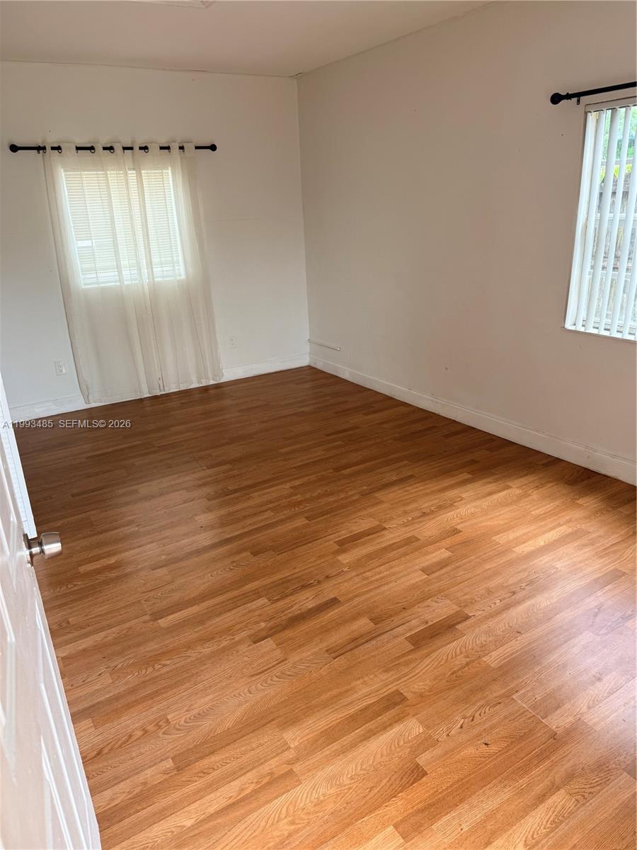 26468 Southwest 123rd Place Homestead, FL 33032 - Photo 23 of 33 an empty room with wooden floor and windows