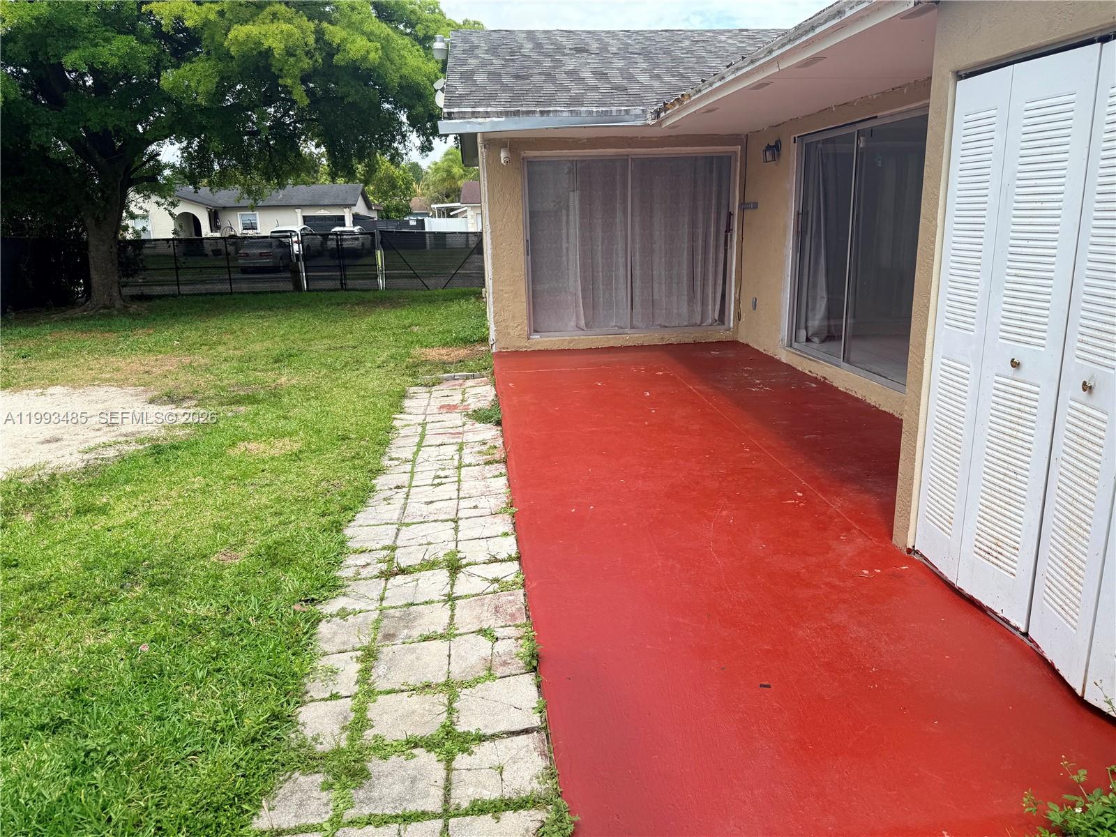 26468 Southwest 123rd Place Homestead, FL 33032 - Photo 27 of 33 a view of a backyard with table and chairs and a small yard