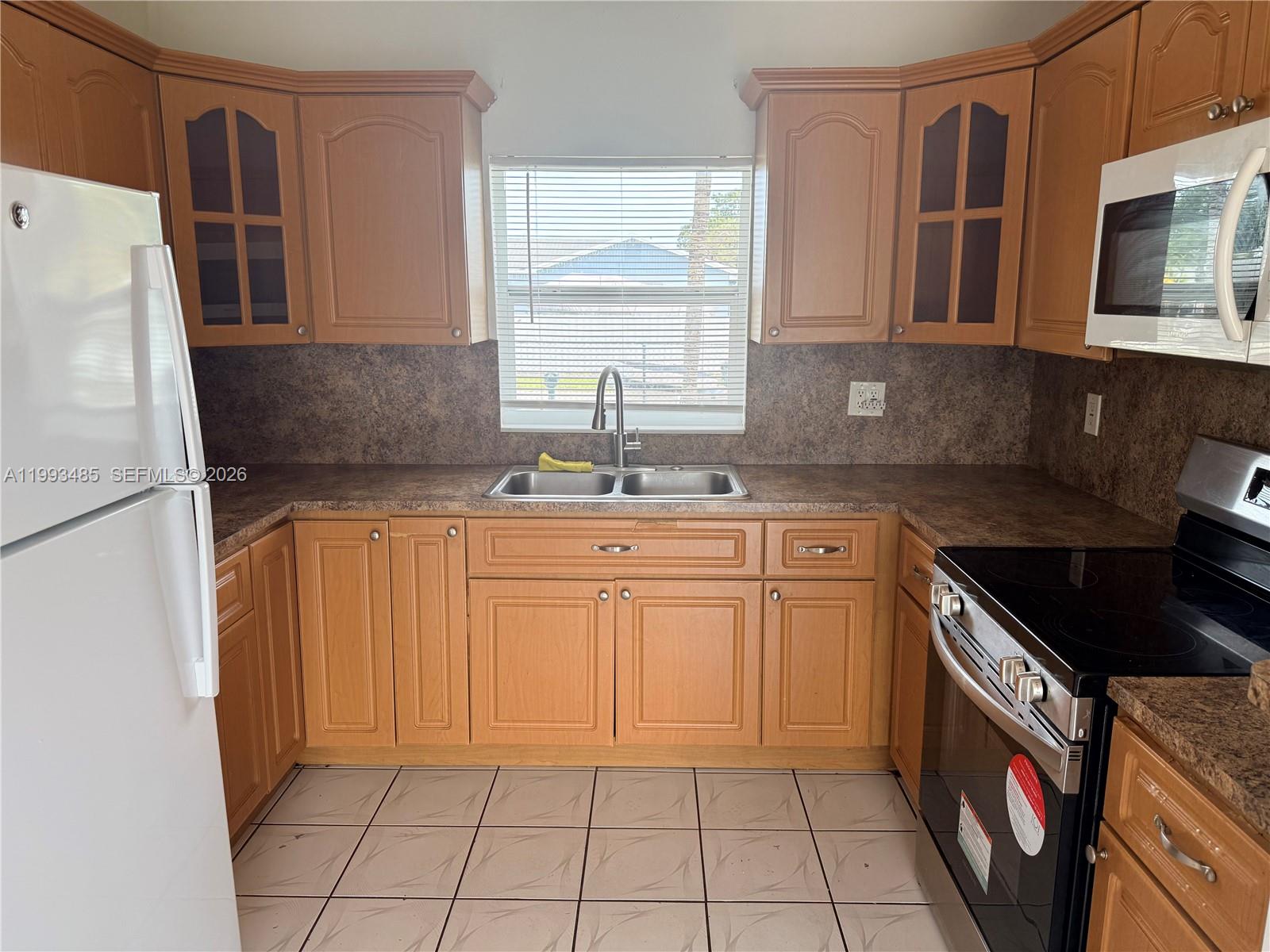26468 Southwest 123rd Place Homestead, FL 33032 - Photo 9 of 33 a kitchen with stainless steel appliances granite countertop a sink stove and refrigerator