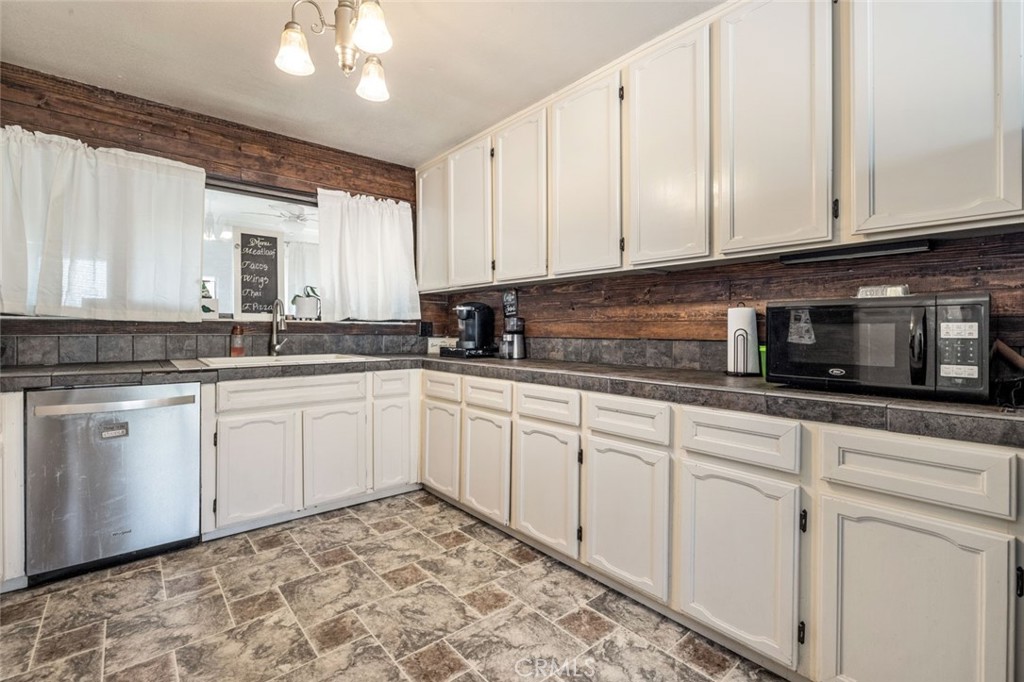 9068 Montero Road Valley Springs, CA 95252 - Photo 14 of 50 a kitchen with stainless steel appliances granite countertop white cabinets sink and dishwasher