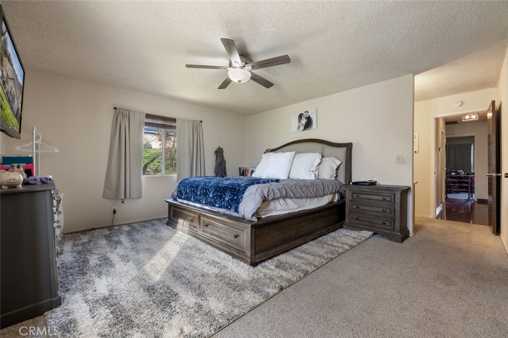 9068 Montero Road Valley Springs, CA 95252 - Photo 28 of 50 a spacious bedroom with a bed and a chandelier