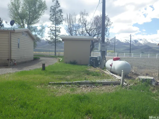 a backyard of a house with table and chairs