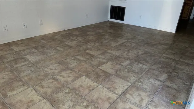 en empty room with wooden floor fan and window