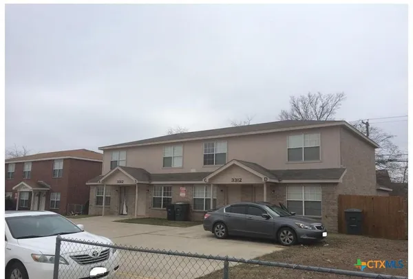 a front view of a house with cars parked