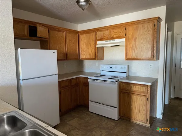 a kitchen with a refrigerator sink and stove