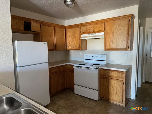 a kitchen with a refrigerator sink and stove