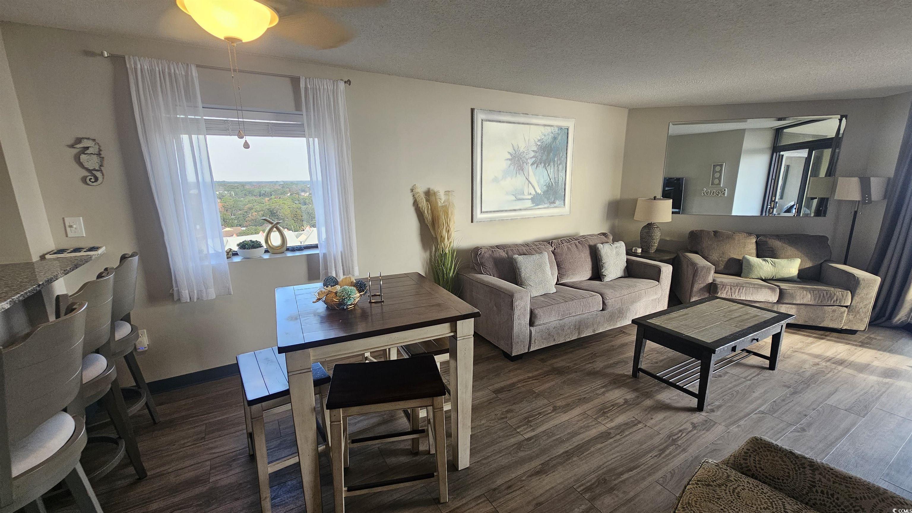 201 74th Avenue North, Unit 1201 Myrtle Beach, SC 29572 - Photo 16 of 40 Living area with dark wood-style floors and a textured ceiling