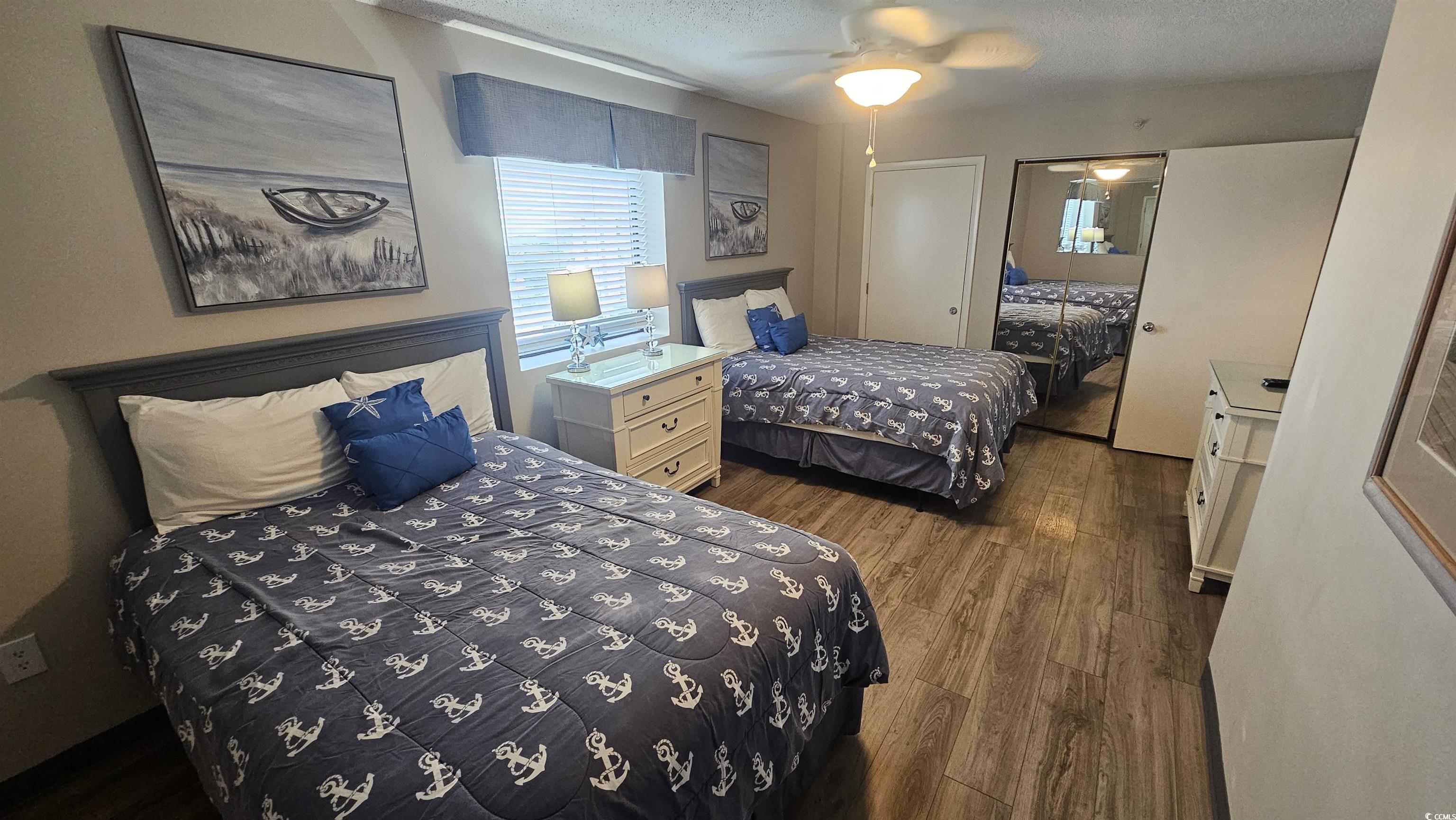 201 74th Avenue North, Unit 1201 Myrtle Beach, SC 29572 - Photo 20 of 40 Bedroom featuring dark wood-style flooring, a closet, a textured ceiling, and a ceiling fan