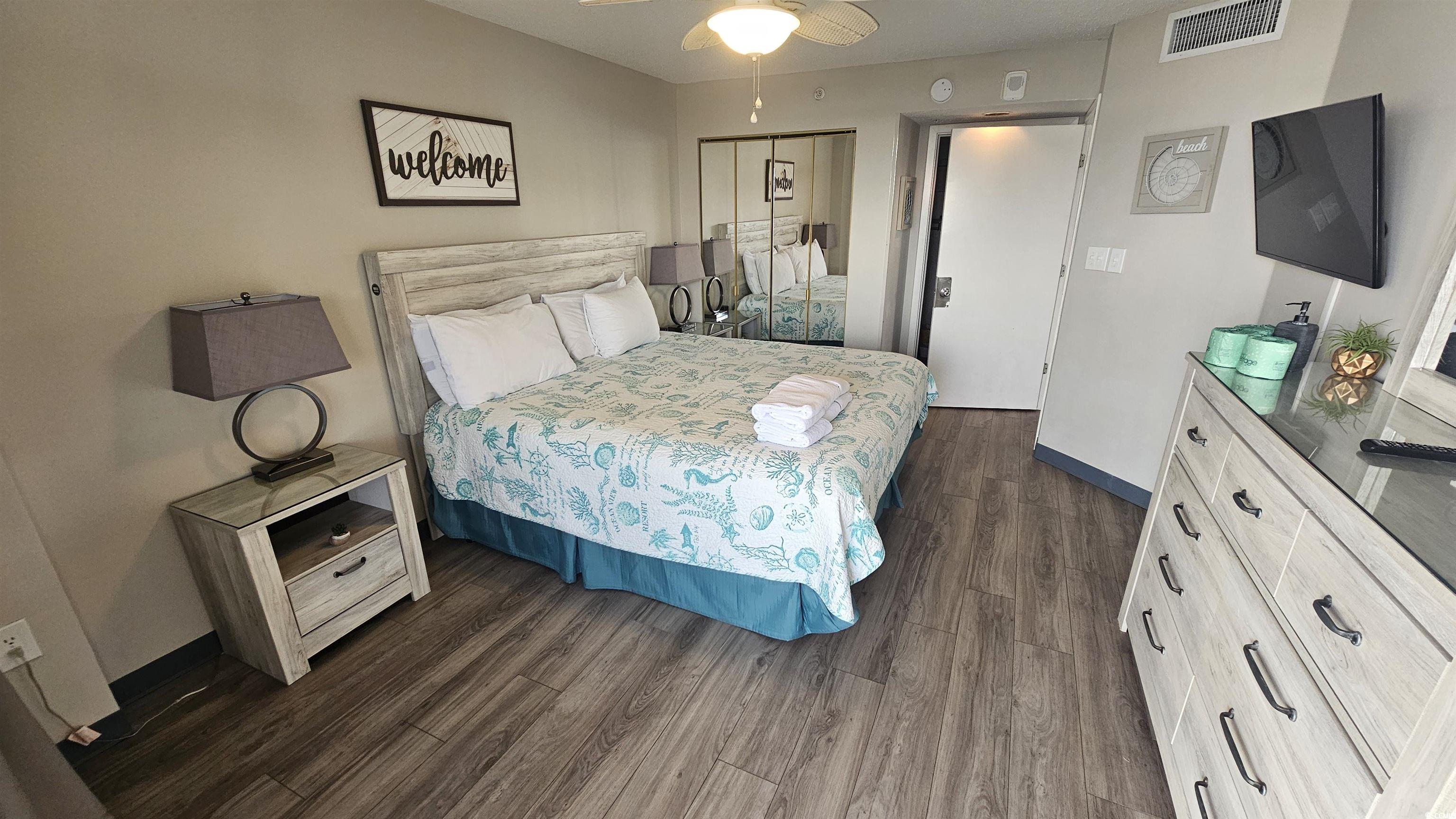 201 74th Avenue North, Unit 1201 Myrtle Beach, SC 29572 - Photo 27 of 40 Bedroom featuring dark wood finished floors, ceiling fan, and a closet
