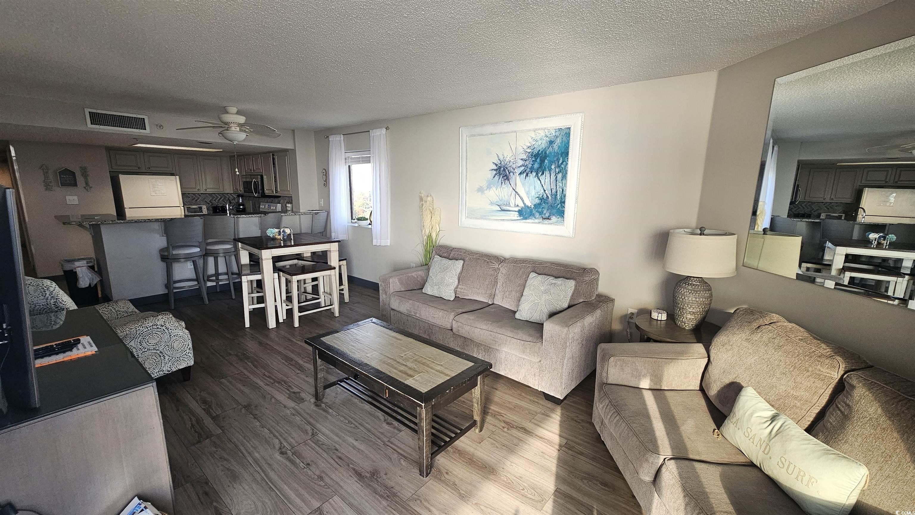 201 74th Avenue North, Unit 1201 Myrtle Beach, SC 29572 - Photo 4 of 40 Living area featuring dark wood-type flooring, a textured ceiling, and ceiling fan