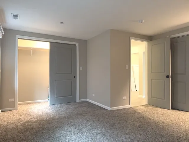 a view of an empty room with closet and a window