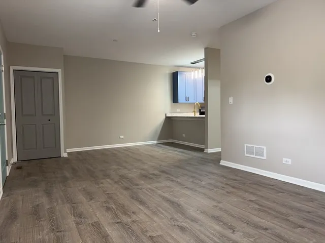 a view of empty room with wooden floor and cabinet
