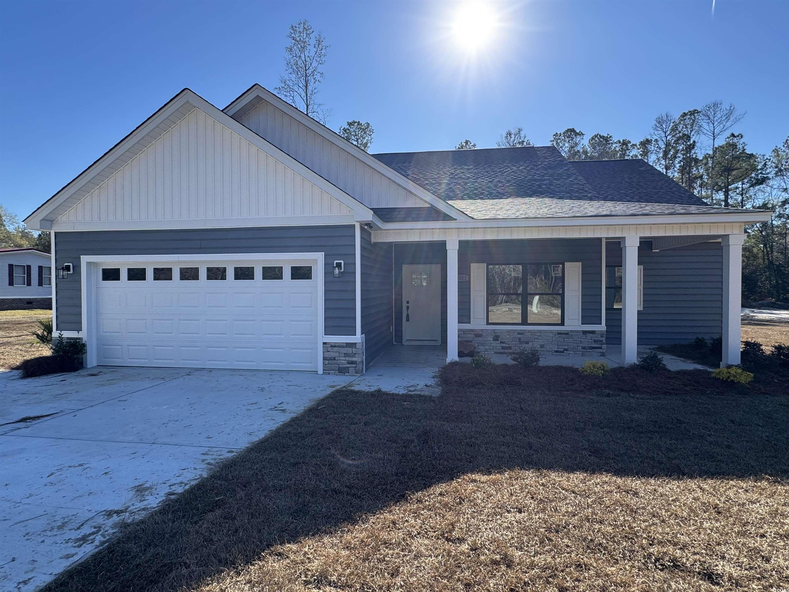 Ranch-style home with stone siding, a porch, concrete driveway, a garage, and a shingled roof