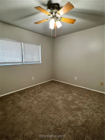 a view of a room with a ceiling fan and window