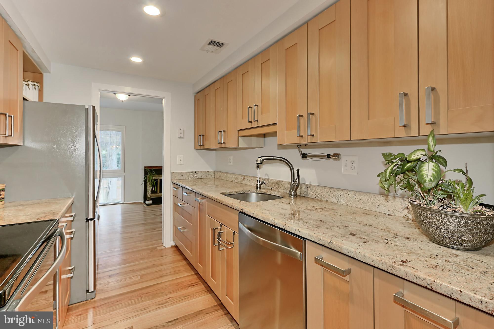 2380 Generation Drive Reston, VA 20191 - Photo 6 of 30 a kitchen with stainless steel appliances granite countertop a sink a stove and a refrigerator