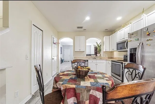 a kitchen with stainless steel appliances granite countertop a dining table and chairs