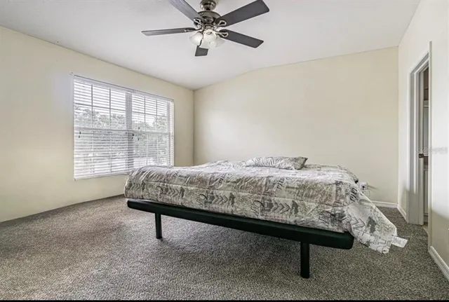 a bedroom with a bed table and window