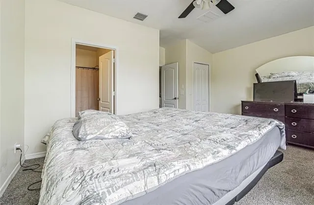 a bedroom with a large bed and a chandelier