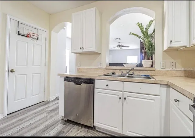 a kitchen with granite countertop white cabinets and white appliances