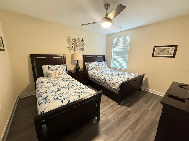 a bedroom with two beds and a desk