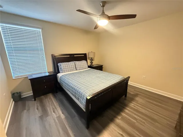 a bed sitting in a bedroom next to a window with a flat screen tv