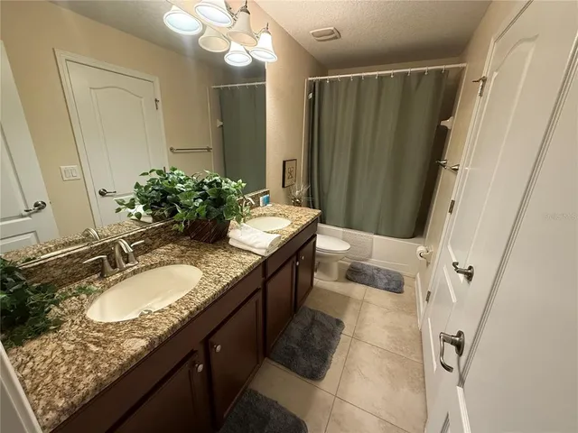 a bathroom with double vanity and a mirror