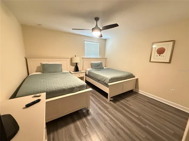 a bedroom with two beds and a ceiling fan