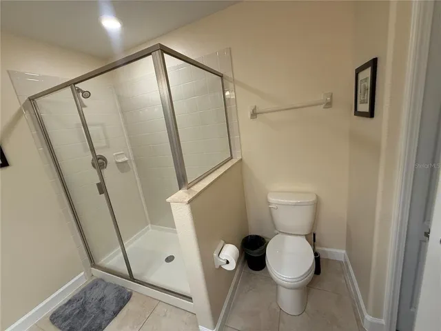 a white toilet sitting next to a shower